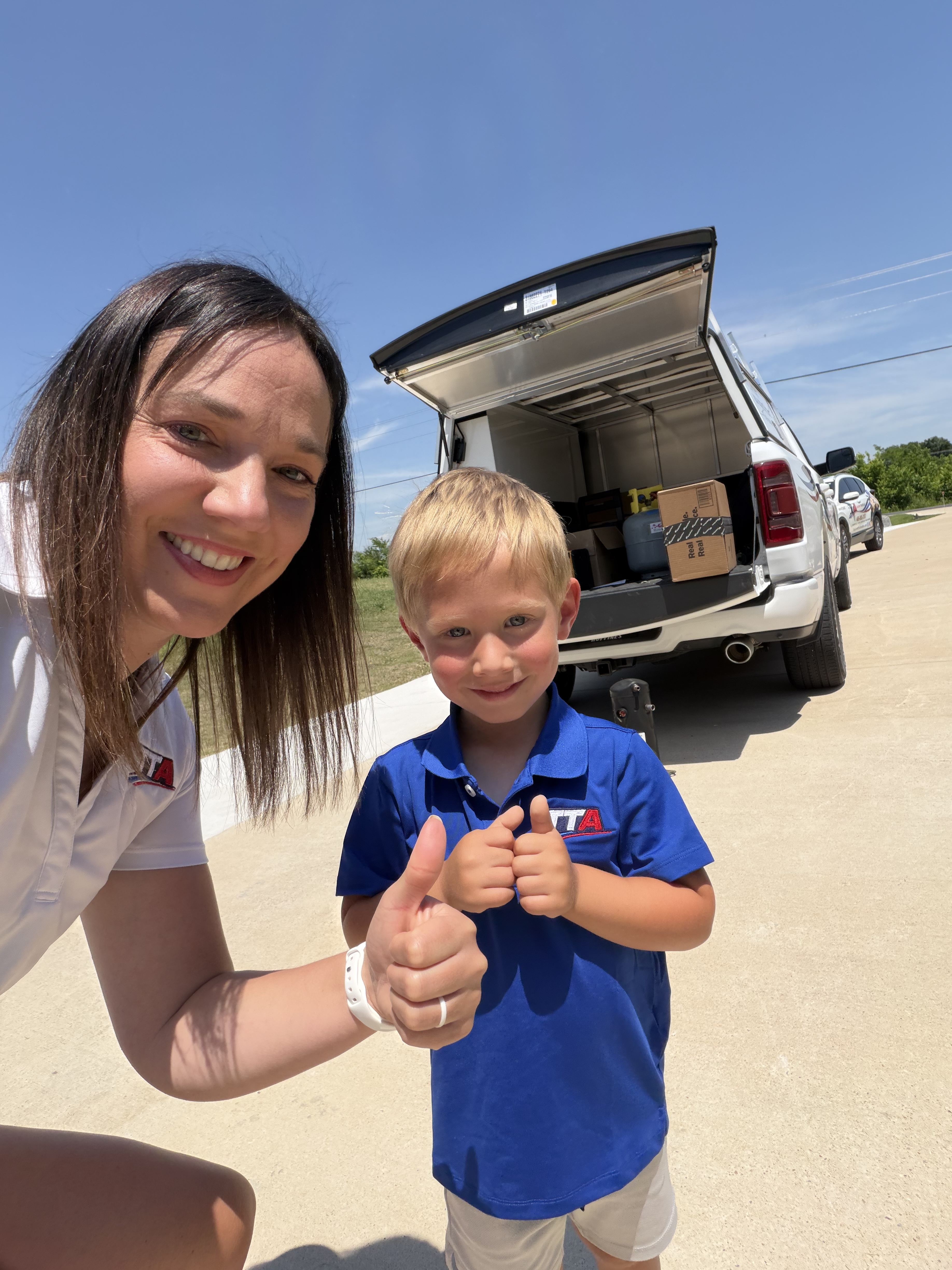Christina and son giving thumbs up by the TTA truck