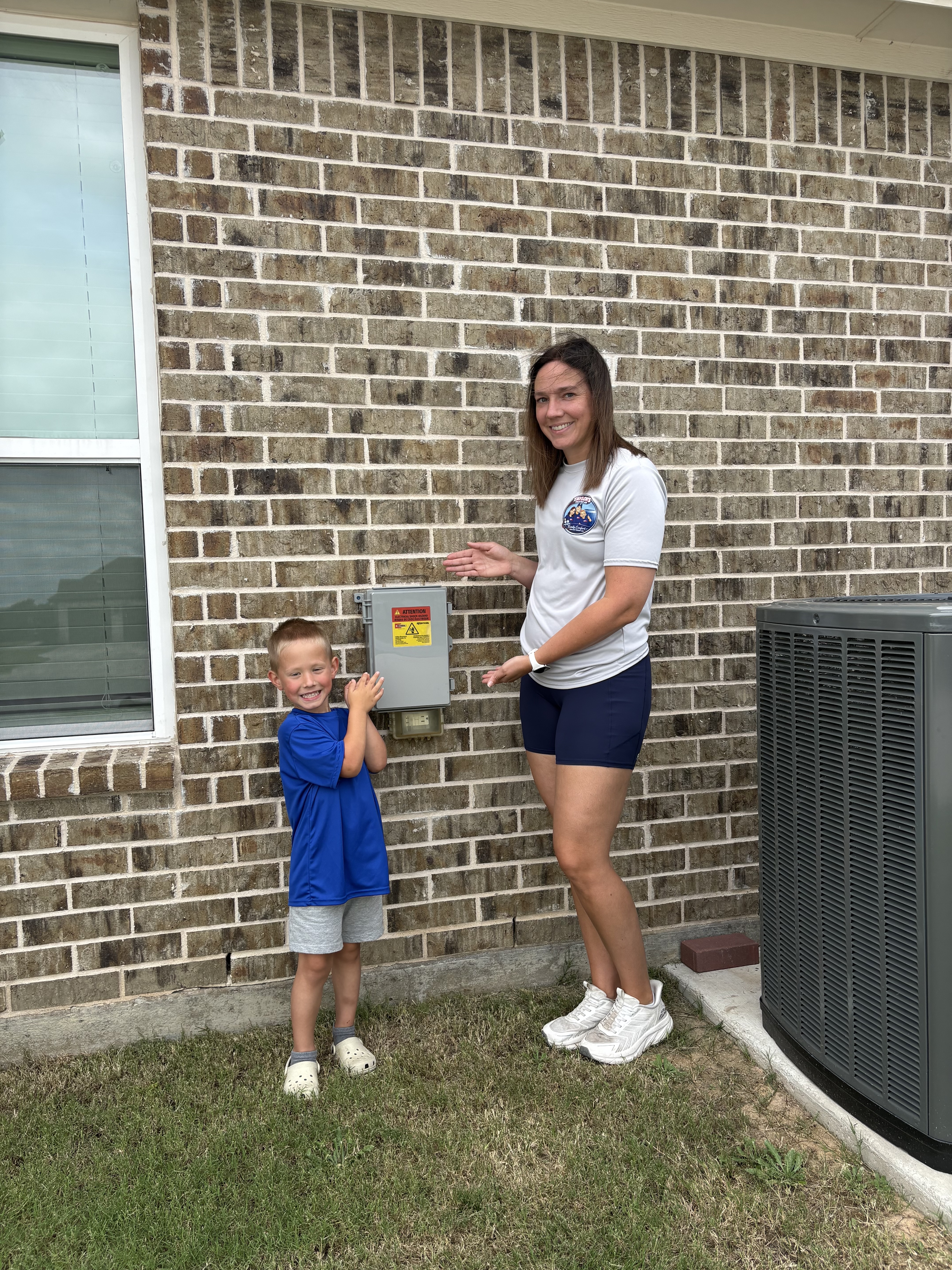 Christina and son showing off a completed AC install