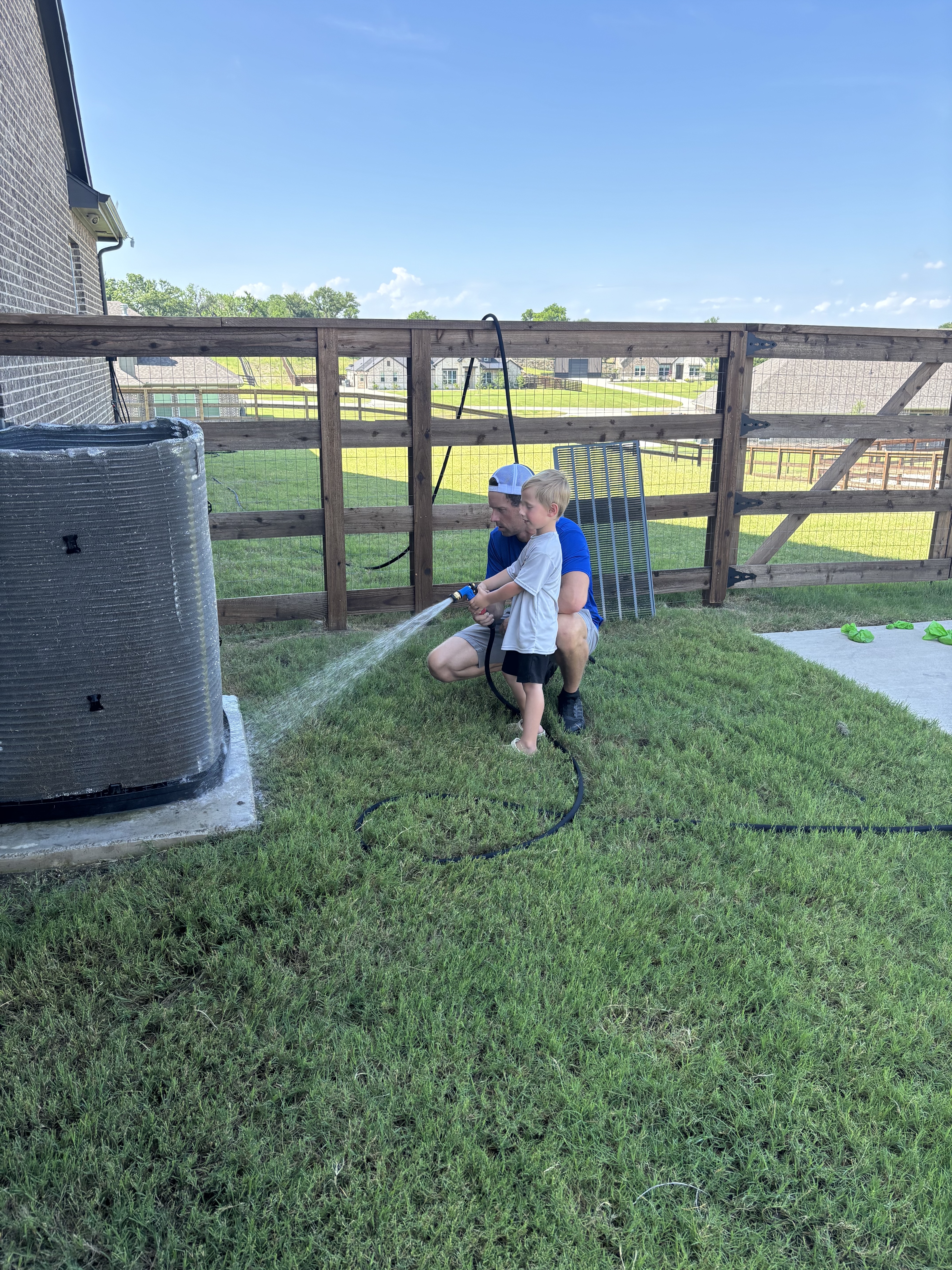 Taylor and son hosing down an AC condenser
